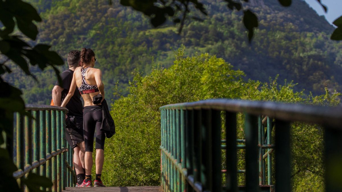 GRAF3825. PROAZA (ASTURIAS), 31/05/2020.- Una pareja observa el vallado de la pequeña osezna Villarina, que fue bautizada así en recuerdo del pueblo donde fue rescatada, en la Senda del Oso, una vía verde que discurre por los concejos de Proaza, Teverga, Quirós y Santo Adriano, todos ellos en el Principado de Asturias. FOTOTECAEFE. FDV. FOTO DE RECURSO. NATURALEZA. AIRE LIBRE. SENDERISMO. SENDA. PASEO. EJERCICIO