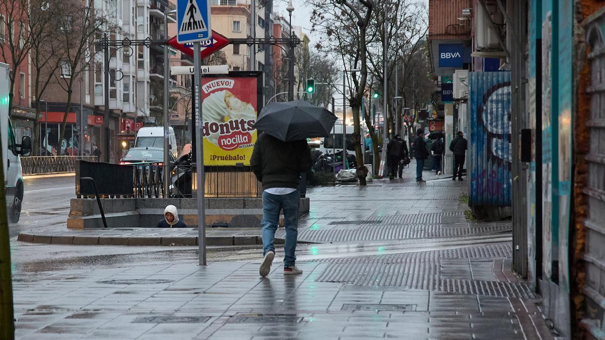 Archivo - Un hombre se protege de la lluvia con un paraguas durante la borrasca ‘Karlotta’, a 9 de febrero de 2024, en Madrid (España).