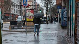 Un hombre se protege de la lluvia con un paraguas durante la borrasca ‘Karlotta’, a 9 de febrero de 2024, en Madrid (España).