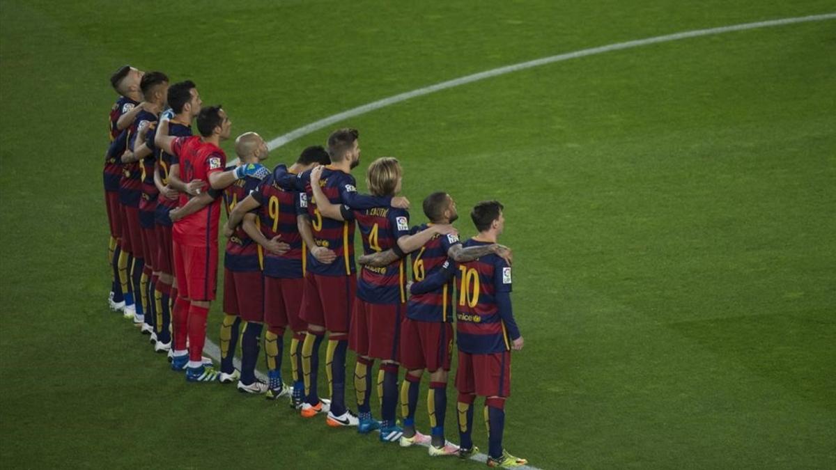 Los jugadores del Barça, abrazados en el centro del campo durante el minuto de silencio