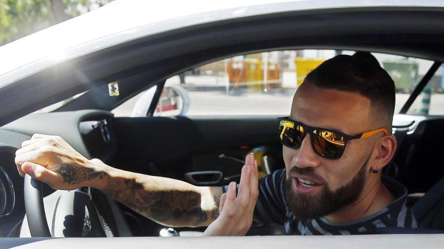 El Otamendi saluda al salir de la ciudad deportiva del Valencia.