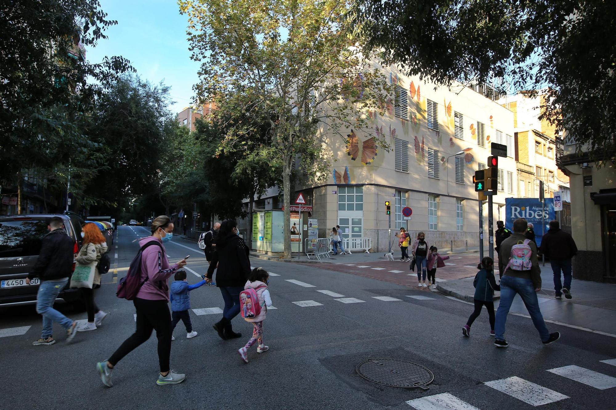 Entrada de la escuela Dovella en la calle Mallorca, llena de coches. Las familias de este colegio del Camp de l'Arpa piden pacificar la zona.