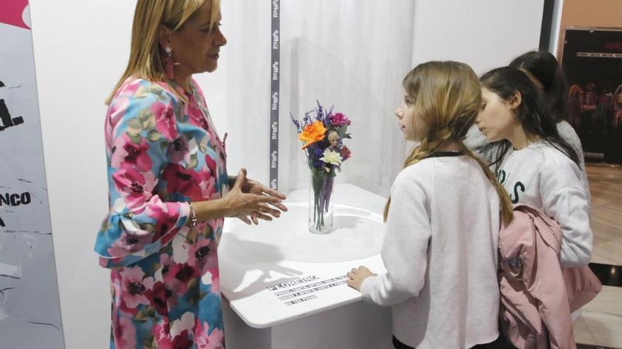 La presidenta provincial charla con tres niñas en la inauguración de una exposición sobre igualdad