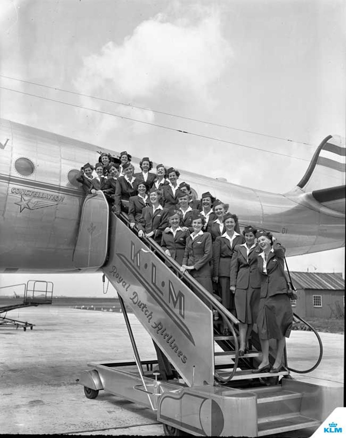 Azafatas de la línea aérea holandesa posando en la escalerilla del avión en 1950