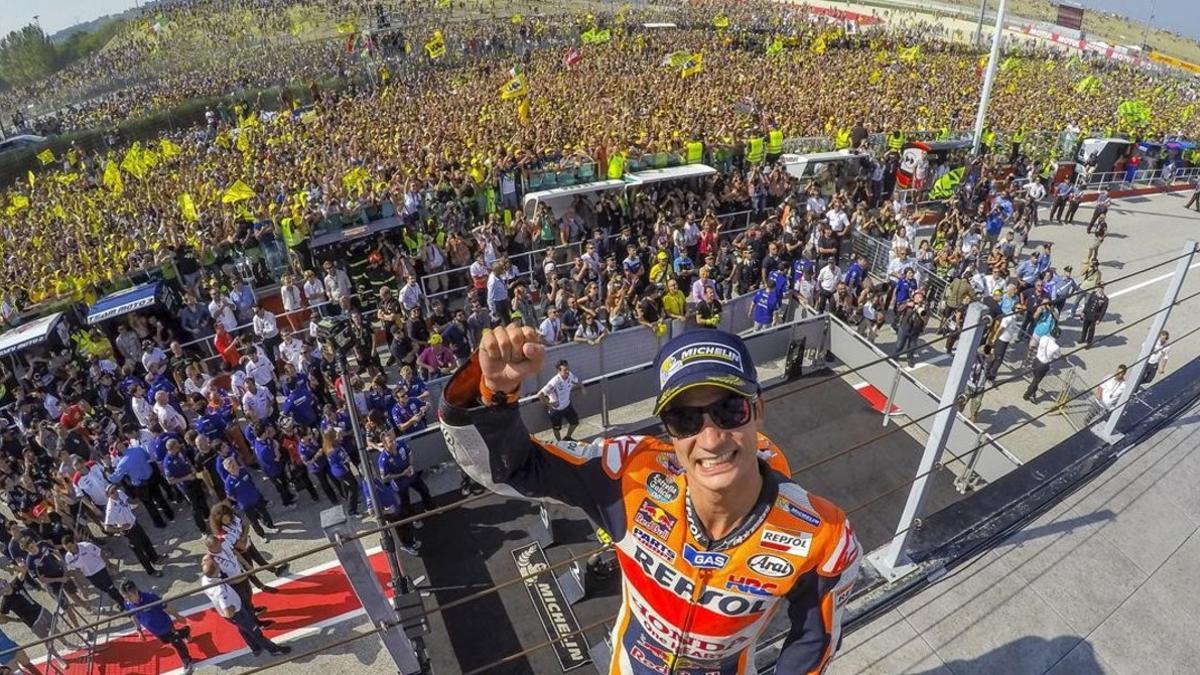 Dani Pedrosa celebra  con la hinchada de Valentino Rossi a su espalda  su victoria en Misano.