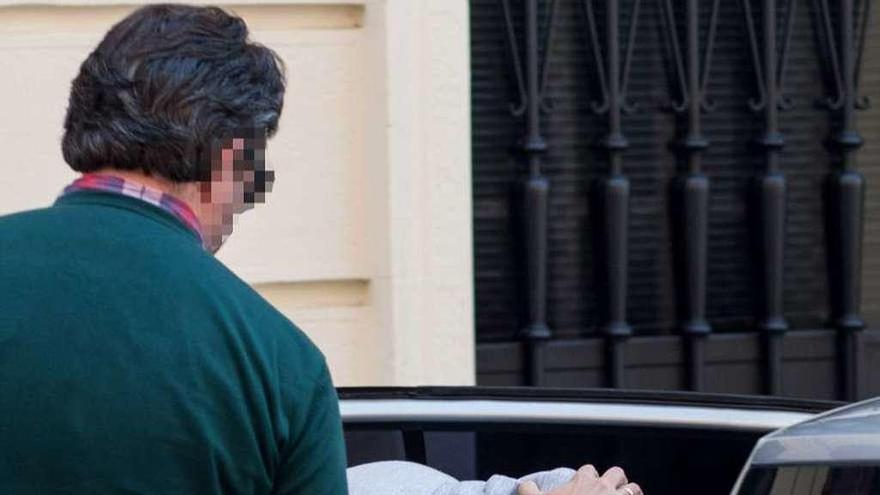 El detenido entra en el coche policial al salir de declarar de la Fiscalía de Menores.