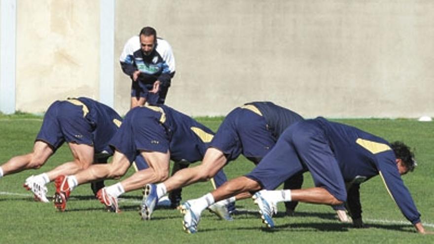 Por el triunfo. Varios jugadores del Málaga hacen ejercicios de velocidad bajo la supervisión del preparador físico, Enrique Ruiz.