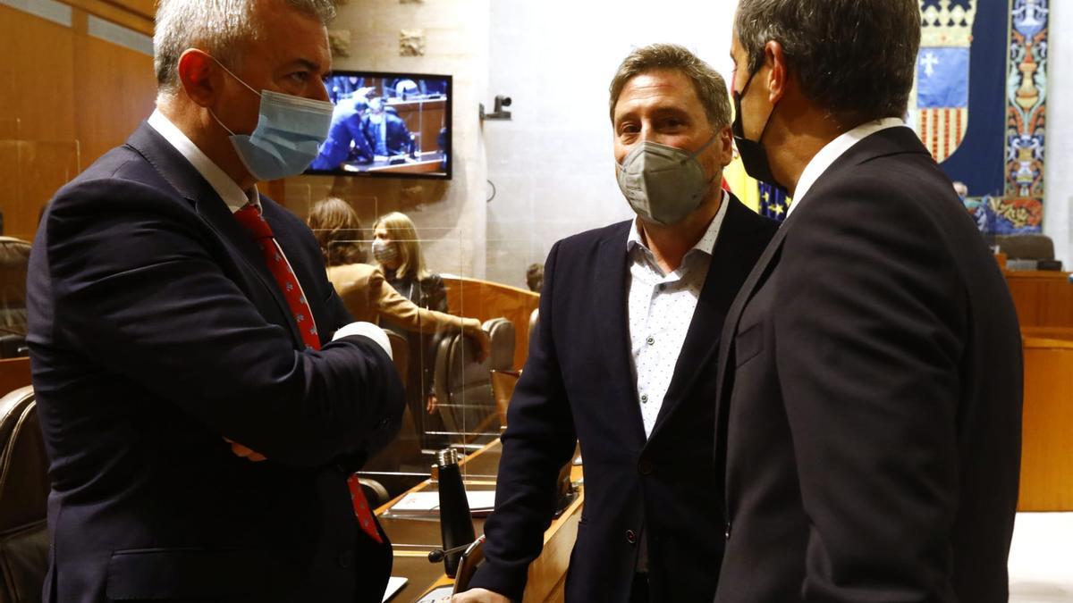 El consejero de Vertebración del Territorio, José Luis Soro, conversa con Javier Campoy (PP) y Javier Martínez (Cs) antes de comenzar la plenaria, este jueves.
