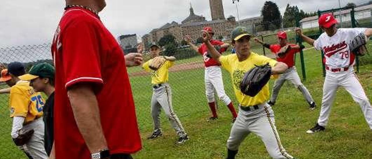 Arriba, Charles Gipson, exjugador profesional de béisbol en EE UU, instruye a un grupo de niños en el campo de la Universidad Laboral.