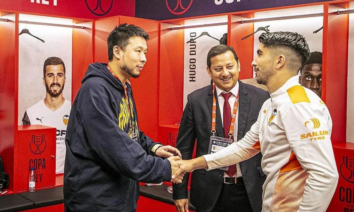 Kiat Lim saluda a Carlos Soler en la final de Copa de 2022, junto con el expresidente Anil Murthy