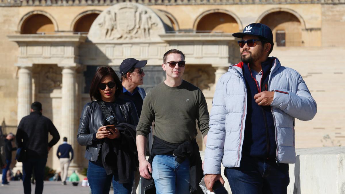 Turistas pasean en el entorno del Puente Romano.