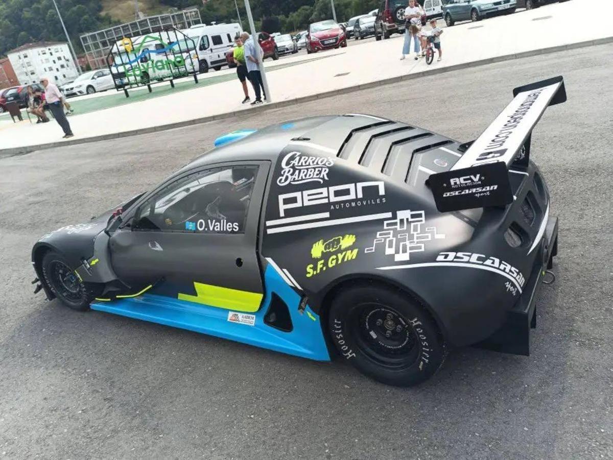 Uno de los coches con el logo de la Asociación Asturiana de Esclerosis Múltiple bajo la puerta del piloto