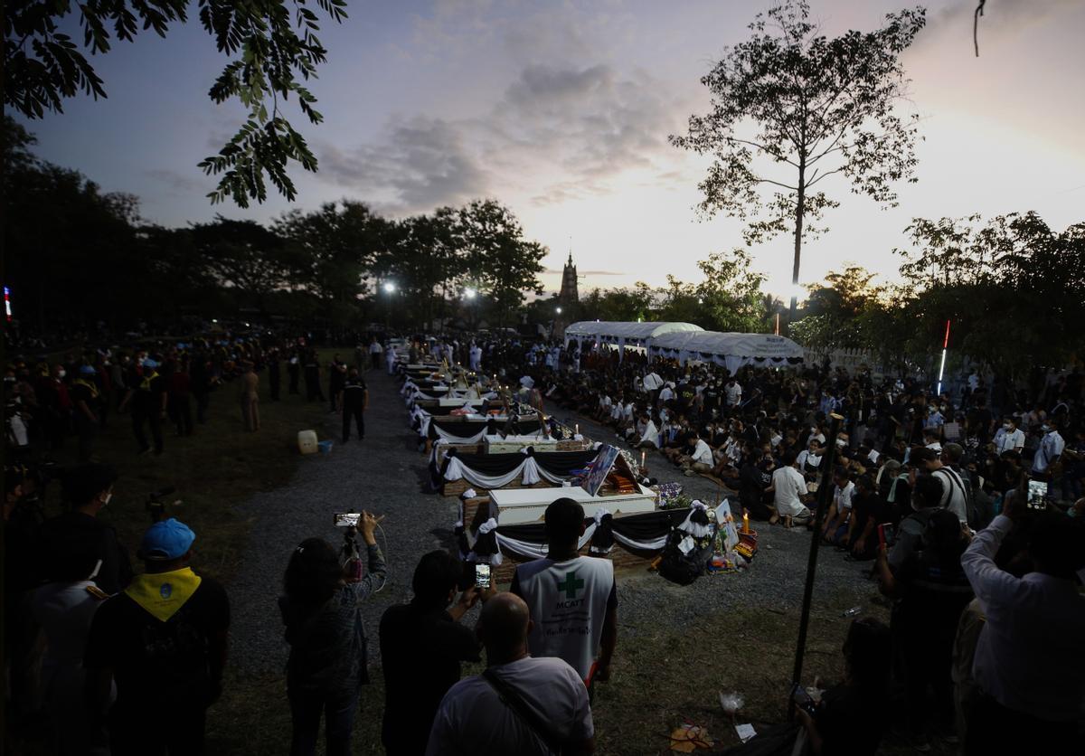 Familiares, amigos y aldeanos rinden su último homenaje a los féretros de sus seres queridos colocados en las piras funerarias durante el rito de cremación masiva patrocinado por la realeza