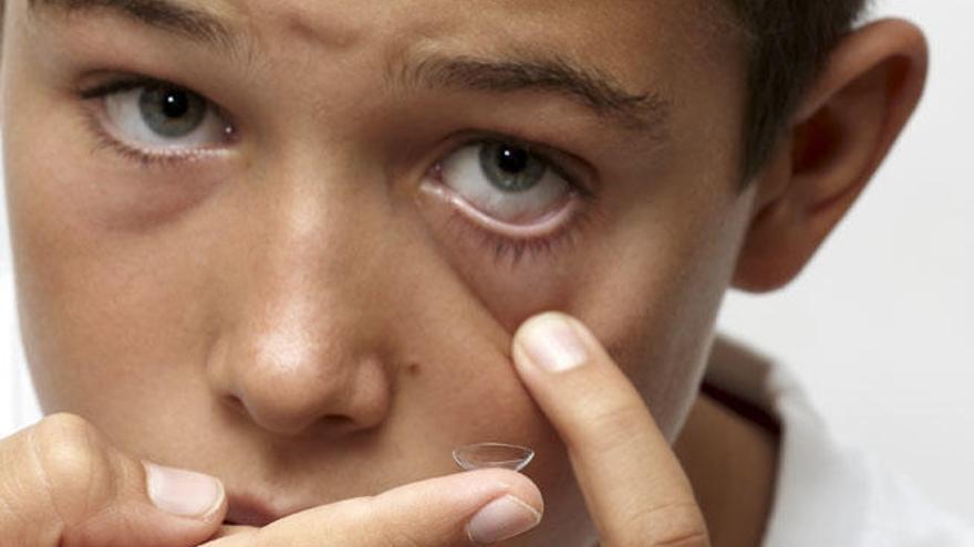 Un niño se coloca unas lentillas.