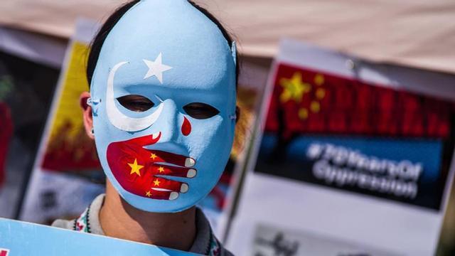 Un home amb la bandera uigur en una protesta a Alemanya contra els crims a la regió de Xinjiang