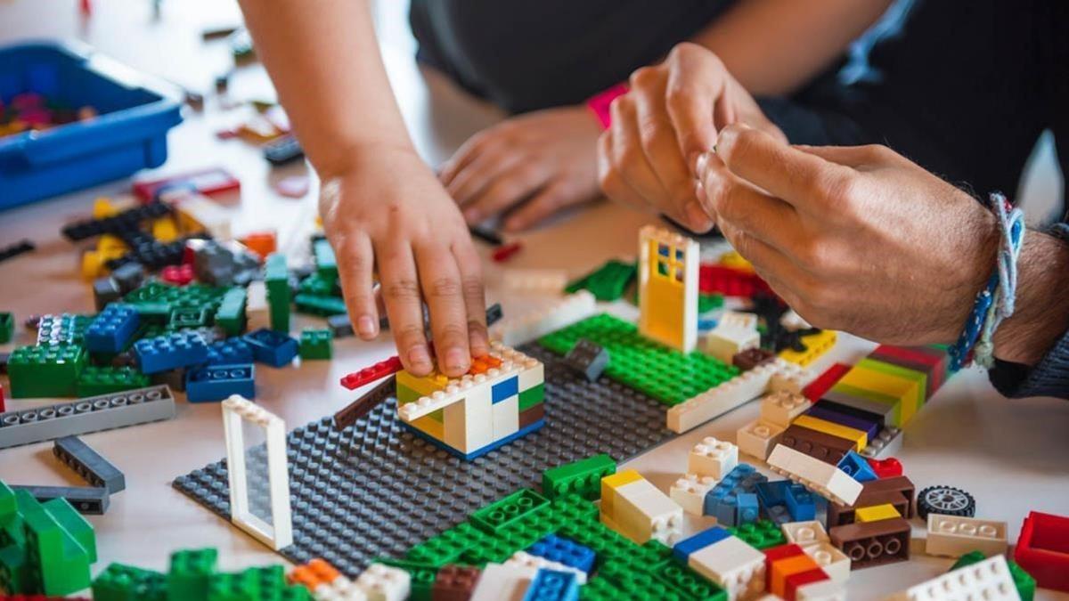 Dos personas jugando con piezas Lego
