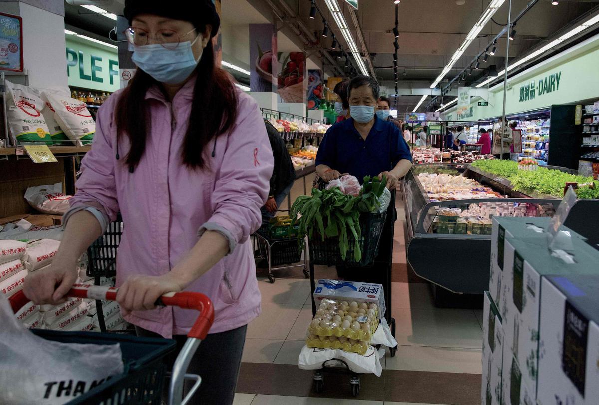 Compra de productos básicos en un supermercado en Pekín, en el momento en el que la ciudad está sumida en el pánico ante un posible confinamiento por covid.