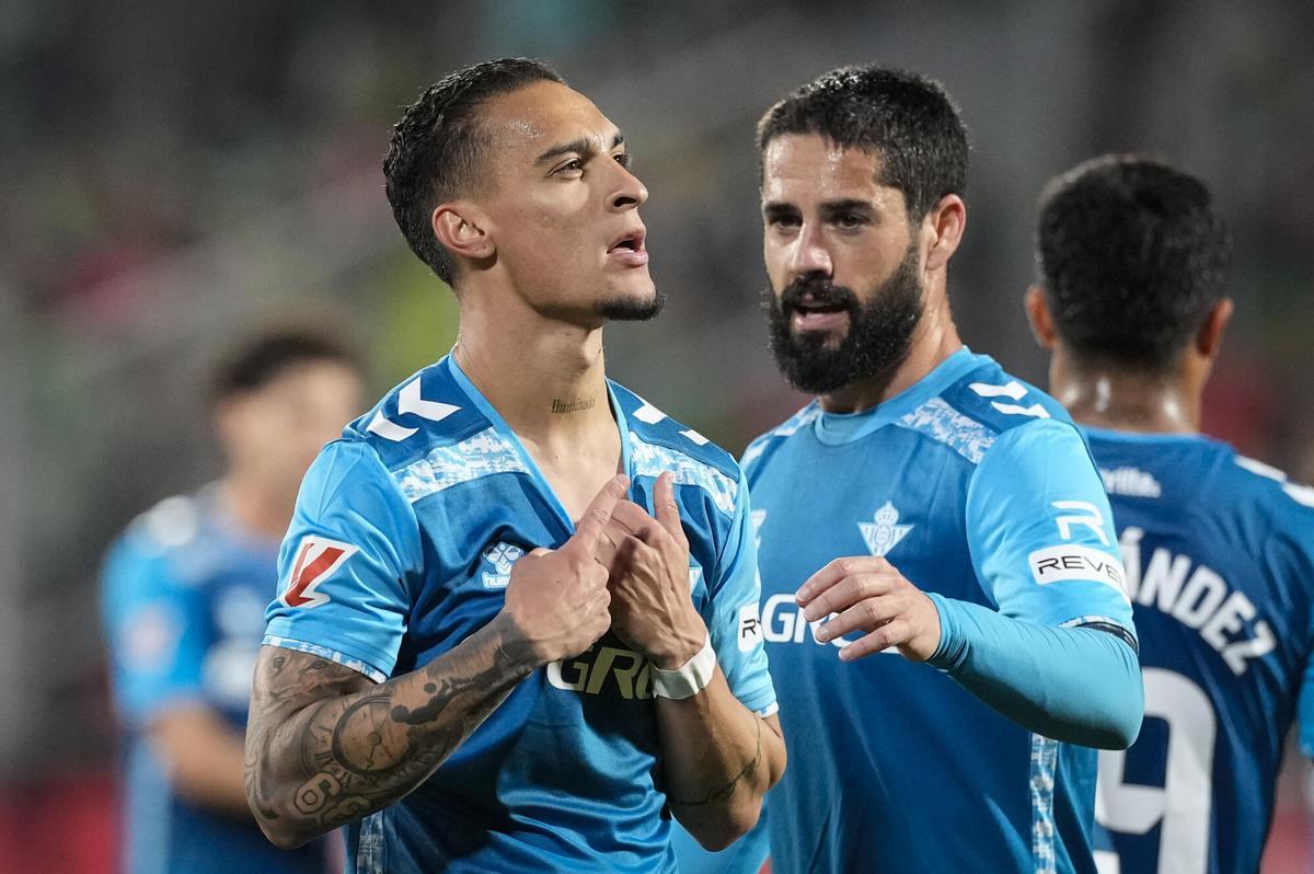 El delantero brasileño del Betis, Antony (i), celebra el segundo gol del equipo bético durante el encuentro correspondiente a la jornada 32 de Laliga EA Sports que disputan Girona y Betis en el estadio de Montilivi, en Girona. EFE / David Borrat.