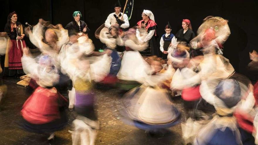 Miembros de la agrupación folclórica &quot;Cuélebre&quot;, durante su actuación en el teatro Filarmónica.