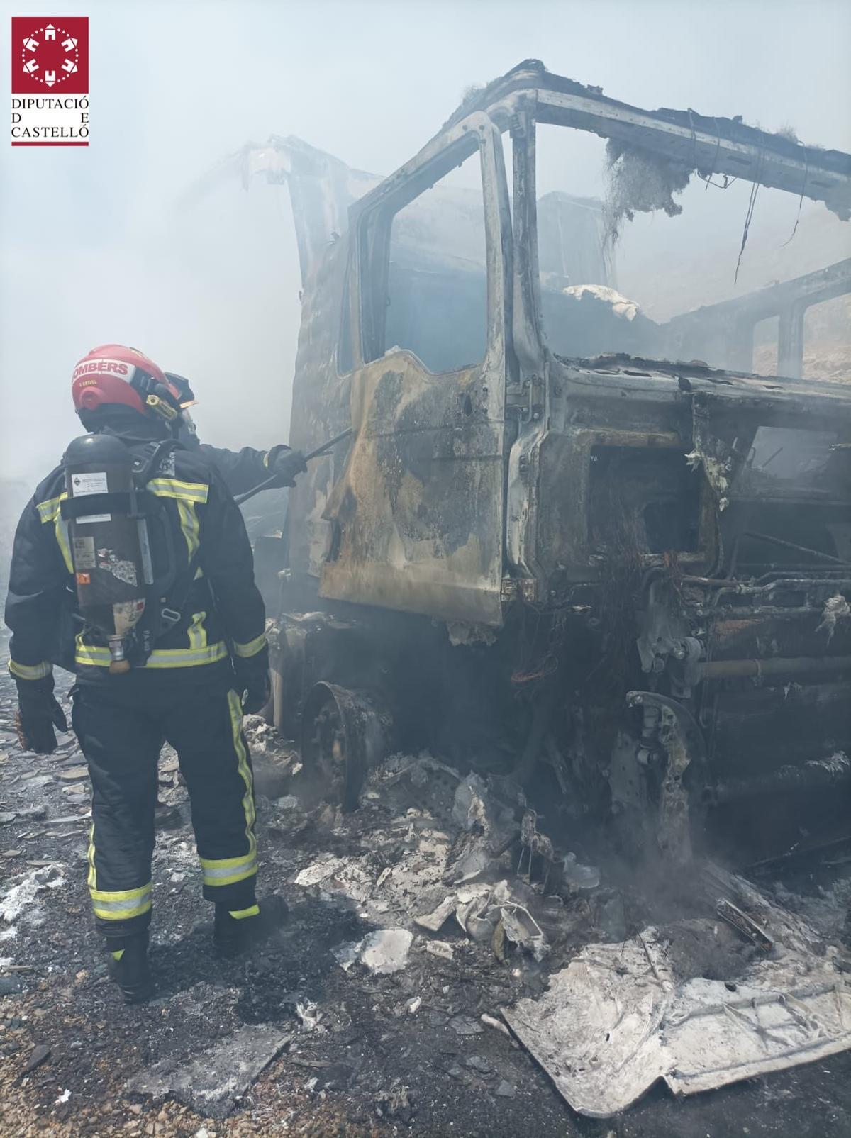 Los efectivos del Consorcio, junto a la cabina, totalmente calcinada.