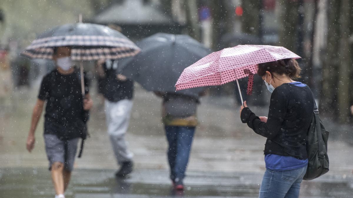 Barcelona. 21.09.2020. Barcelona. Paseantes por la Ramblas protegiéndose de la lluvia con sus paraguas. Fotografía de Jordi Cot