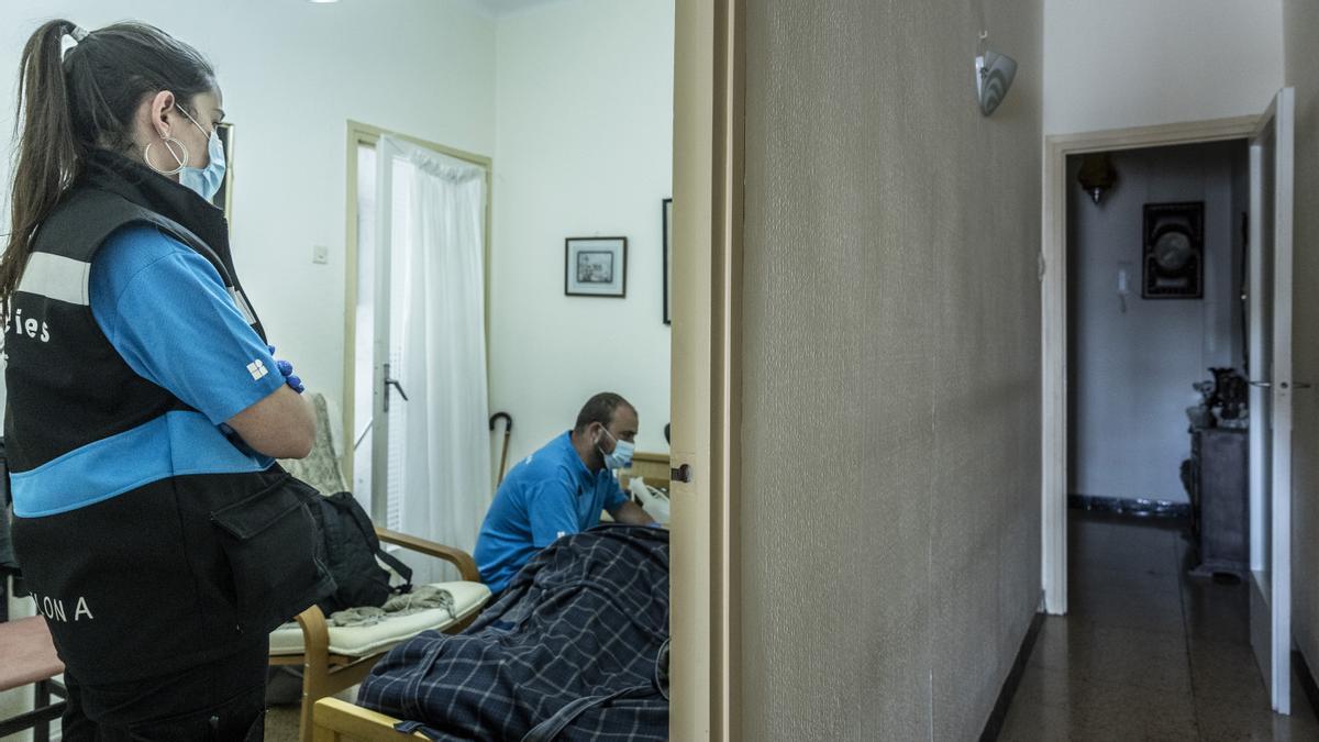 Dos técnicos del CUESB atienden a una persona mayor en un domicilio de Sant Martí.