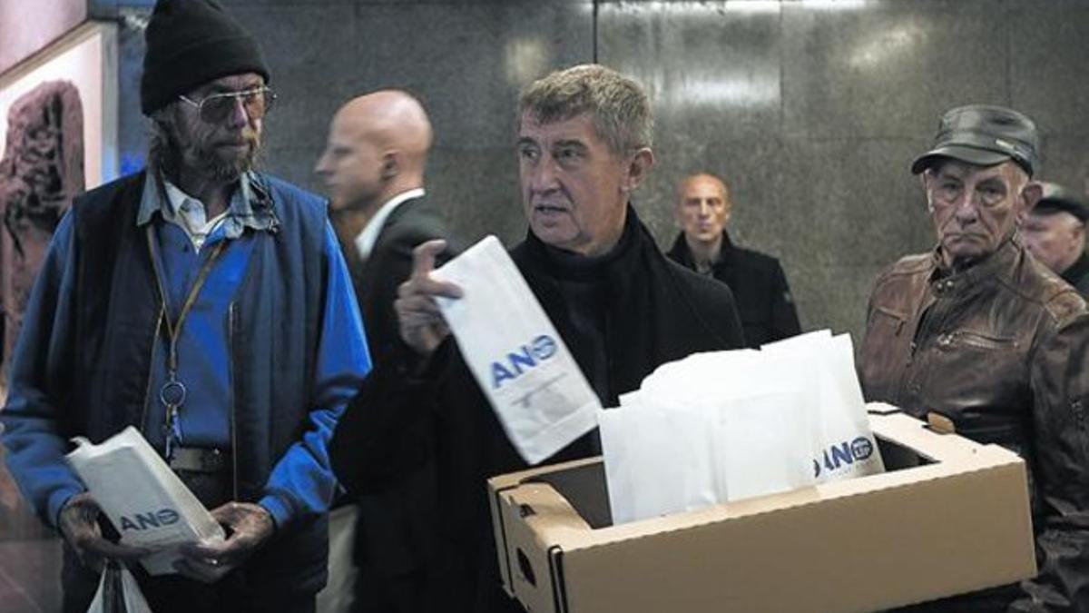 Generoso 8 Babis, en el centro, reparte bolsas con donuts en Praga durante la campaña.