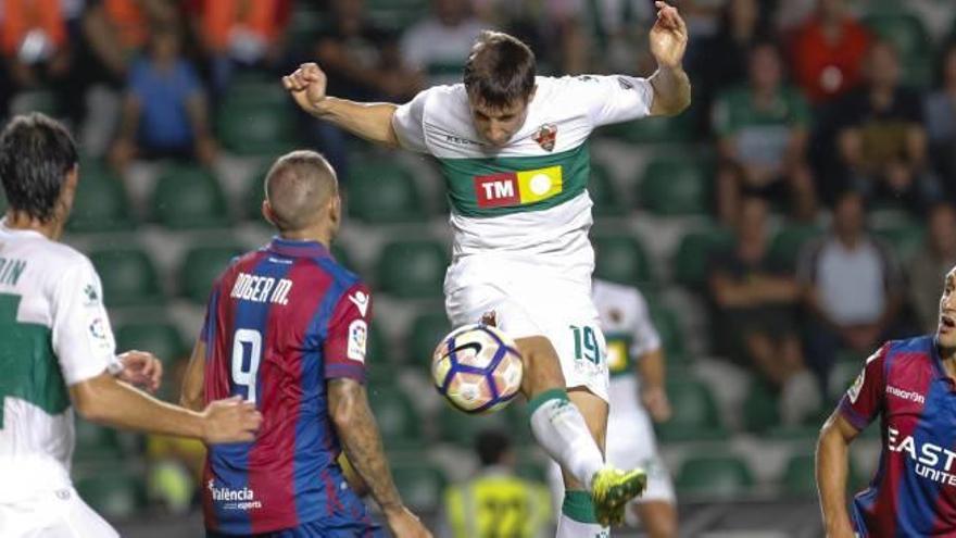 Guillermo salta con Roger durante el partido de la primera vuelta disputado en el Martínez Valero.