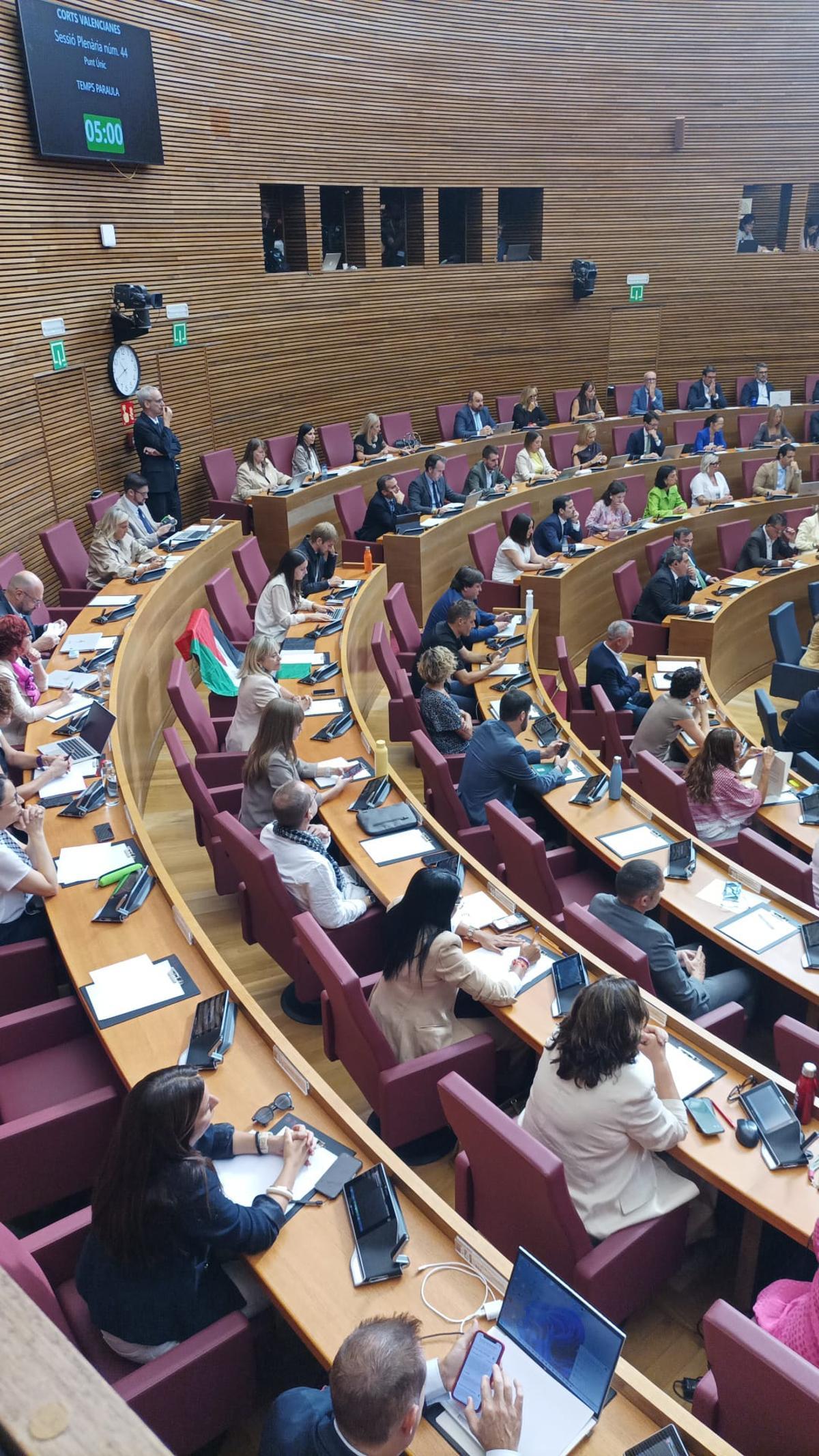 Una bandera palestina cubre el escaño vacío de Juan Bordera, de Compromís.