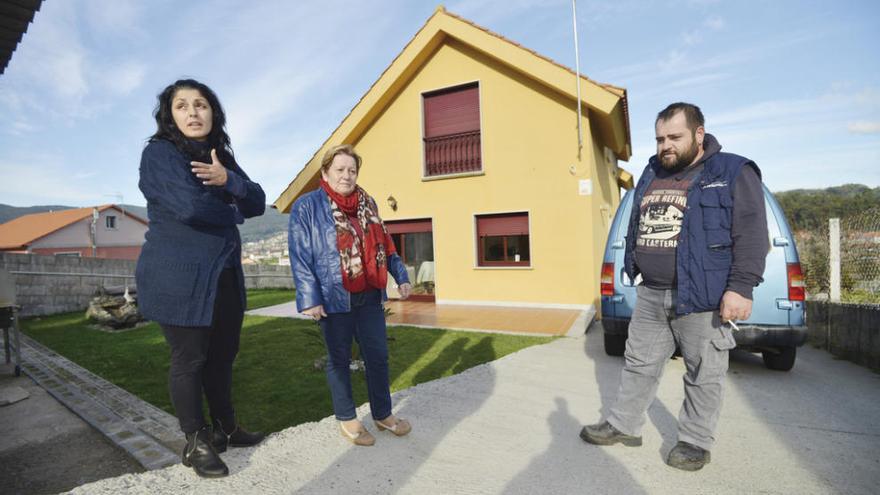 Los padres y la abuela de la menor ante la casa asaltada. // G. Santos