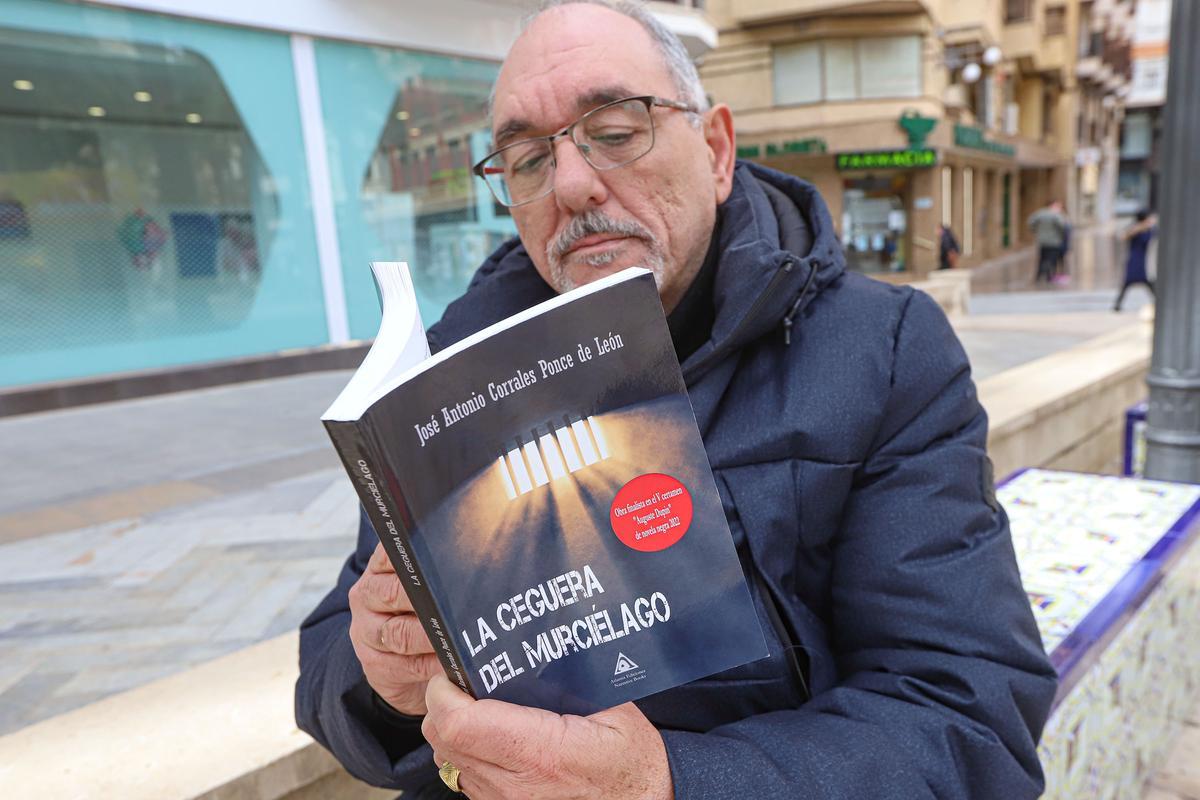 José Antonio Corrales lee el libro sentado en un banco de la Glorieta.