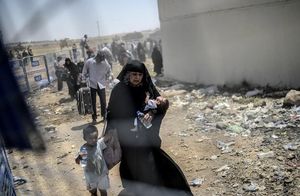 Una refugiada siriana, exhausta, passa amb els seus fills a Turquia.