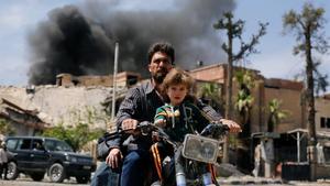 Un hombre con un niño conduce una motocicleta, en Duma.