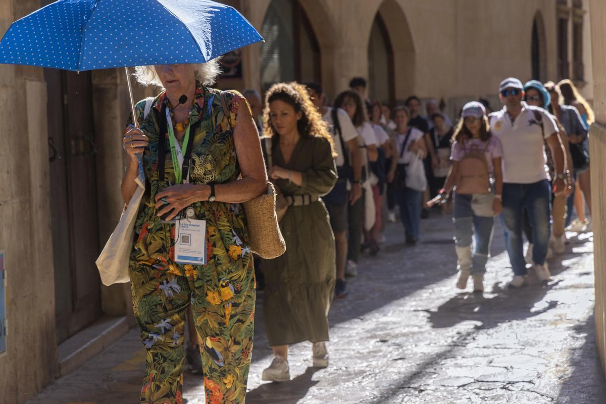 Turistas siguen a una guía por el centro de Palma de Mallorca.