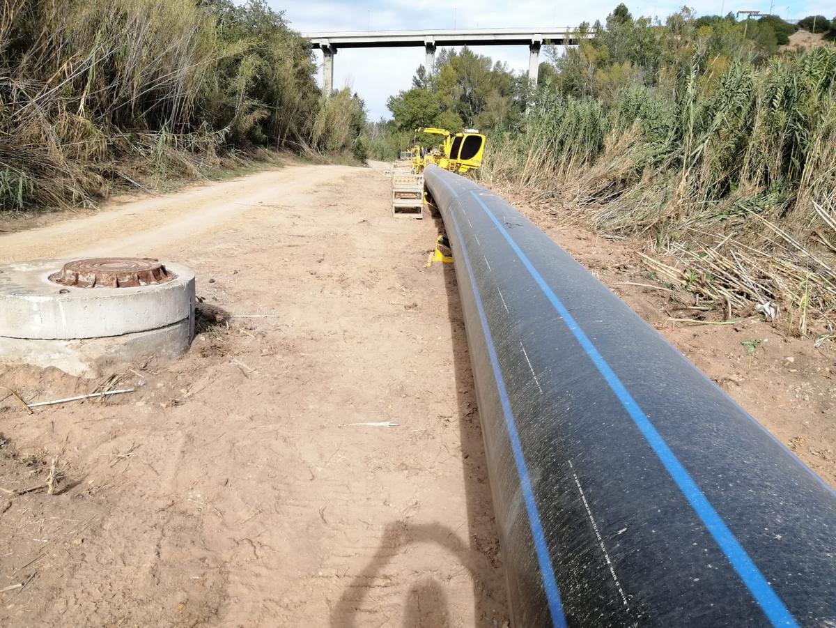 La canalització estesa al costat del riu, sota el viaducte d'accés a l'autopista