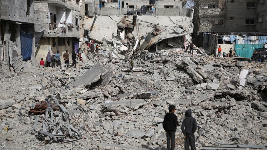 Palestinos frente a un edificio destruido por un bombardeo del Ejército de Israel contra la ciudad de Rafá, en el sur de la Franja de Gaza (archivo).