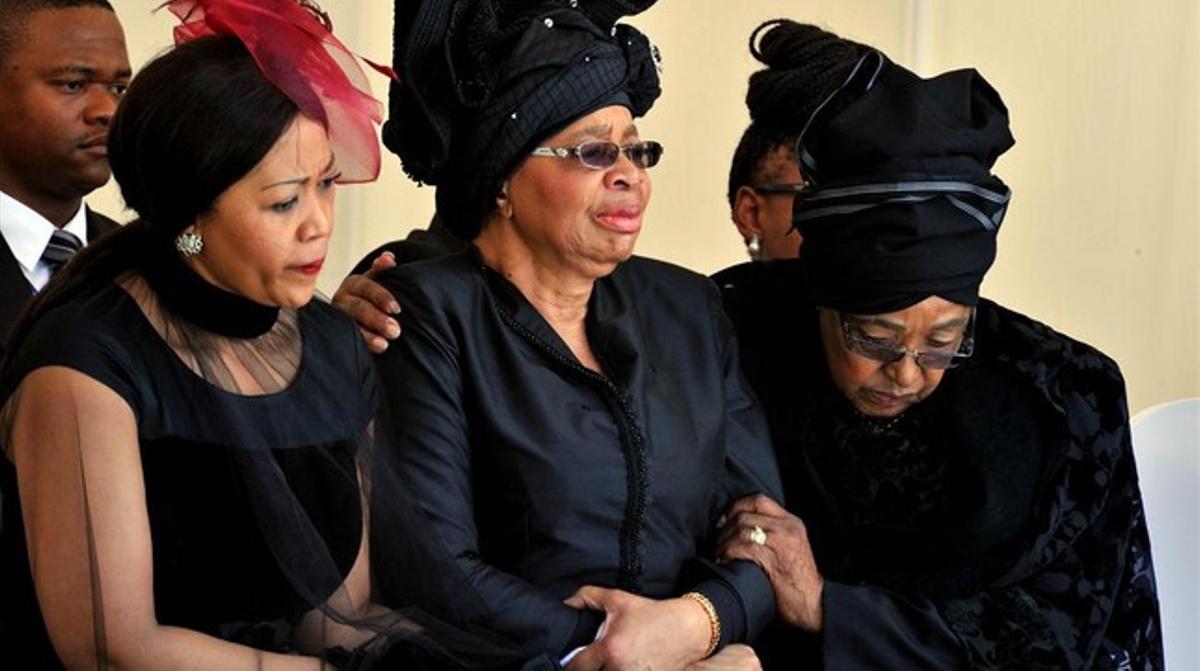 Winie Mandela, la segunda esposa del líder, conforta a la viuda Graça Machel.