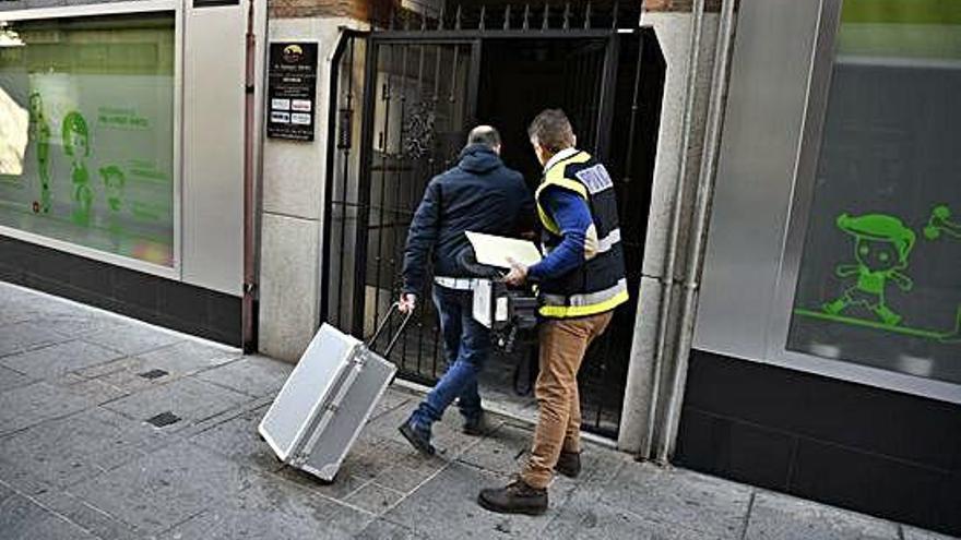 Agentes de la Policía científica acceden al portal de la vivienda donde tuvo lugar el crimen, en Puertollano.