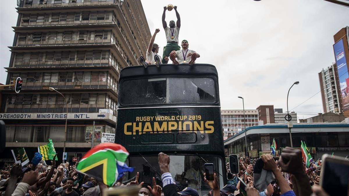 Los jugadores de Sudáfrica, héroes del Mundial de rugby desfilan con la Copa ganada en Japón.