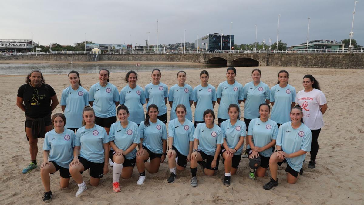 Por la izquierda, de pie, Arturo García (preparador físico), Mara Coto, Isabel Lobo, Andrea Santos, Rocío Robledo, Celia Arrivas, Ari Vieira, Jimena Díaz, Yara Labrador, Oli de Hijes y Ana María de la Riva. Agachadas, también por la izquierda, Candela Lage, Ana Río, Alma Luis, Alba Álvarez, Alba González,Valeri Requena, Yara García, Erika Cea y Sarai Díaz, ayer, en la playa de San Lorenzo. | Juan Plaza