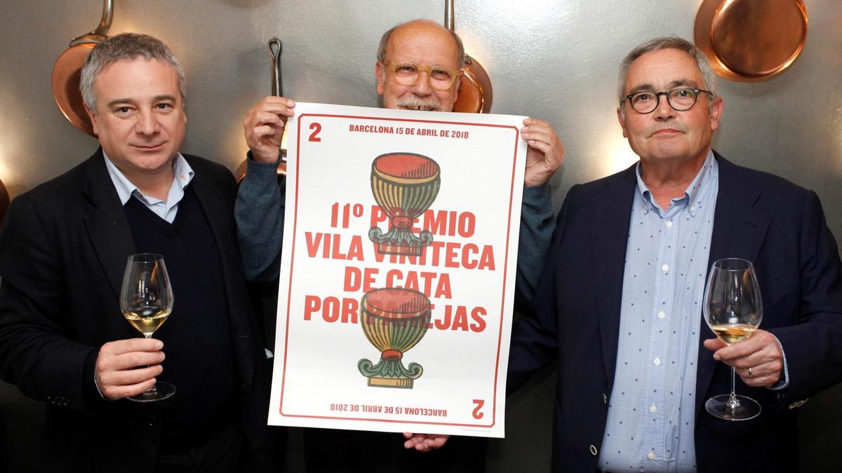 El diseñador Claret Serrahima, entre los dueños de Vila Viniteca, Quim Vila y Siscu Martí, con el cartel que hizo para la 11ª edición del Premio Vila Viniteca de Cata por Parejas.