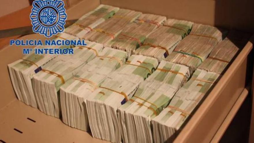 Una de las cajas halladas en la casa, llena de fajos de billetes de 100 euros atados con gomas.