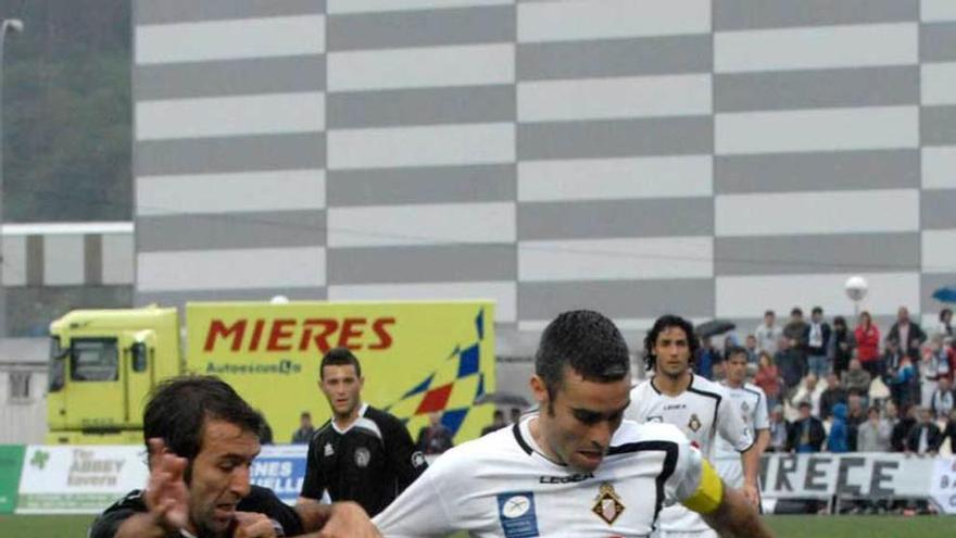 Invernón protege el balón ante un jugador de L&#039;Hospitalet en la fase de ascenso a Segunda de la temporada 2012-13.