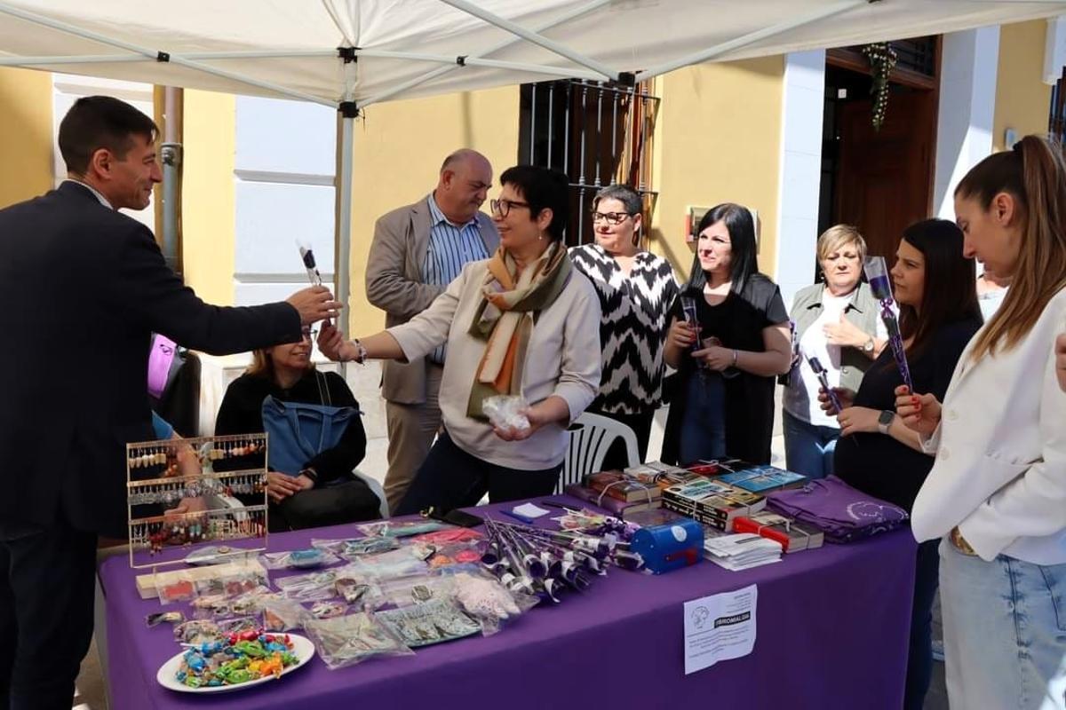 El alcalde de Burjassot, Rafa García, recibe una rosa morada de la Asociación de Fibromialgia.