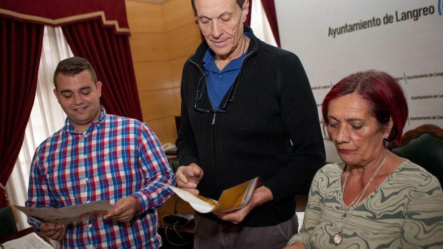 Enol Zapico, Jesús Sánchez y Guillermina Quintana consultan el programa de las fiestas gastronómicas.