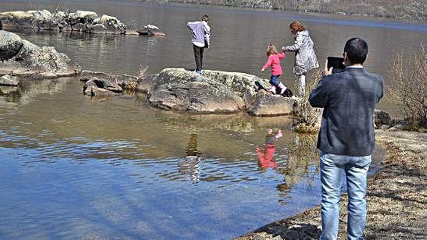 Una familia visita el Lago de Sanabria en el otoño.