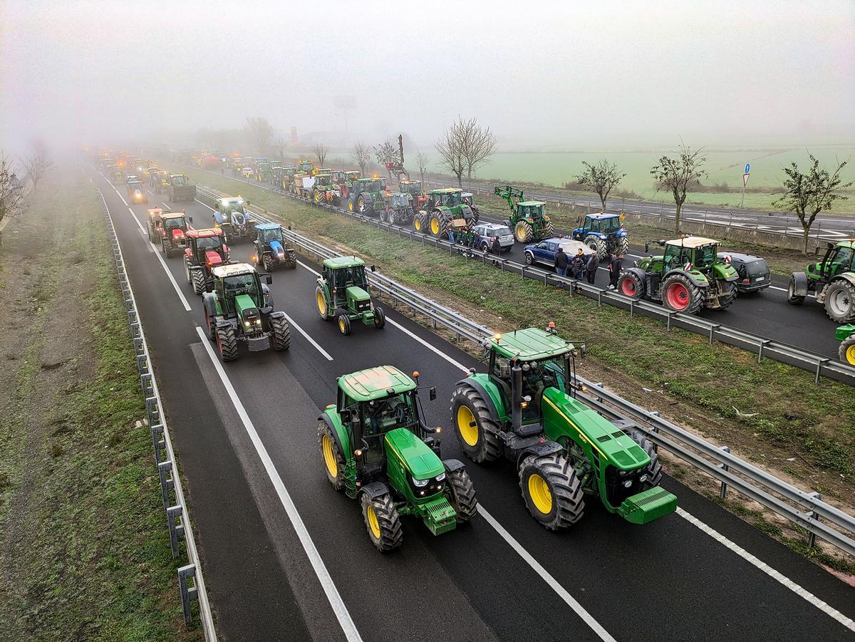 Agricultores con tractores cortan el paso en la autovía NII a su paso por Fondarella, en el Pla dUrgell (Lleida).