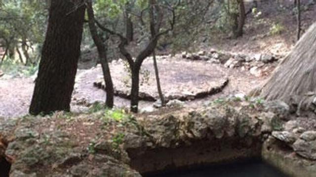 En primer término, el depósito para recoger agua y, al fondo, el 'rotlo de sitja' y la barraca del 'carboner'.