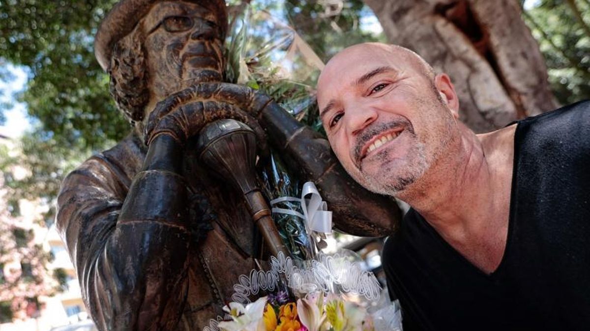 El murguero Juan Díaz, junto a la escultura del padre del género, Enrique González, que está en la plaza del Príncipe.