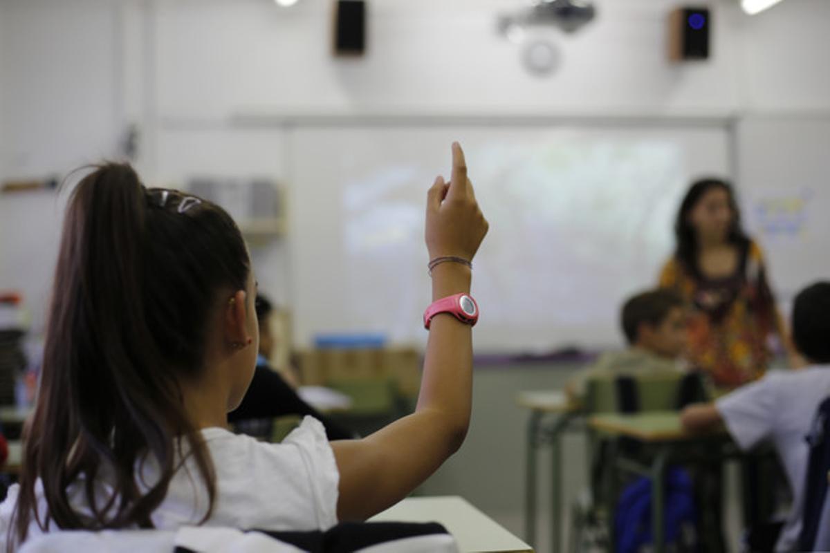 Alumna levanta la mano en una clase del centro CEIP Reixac.